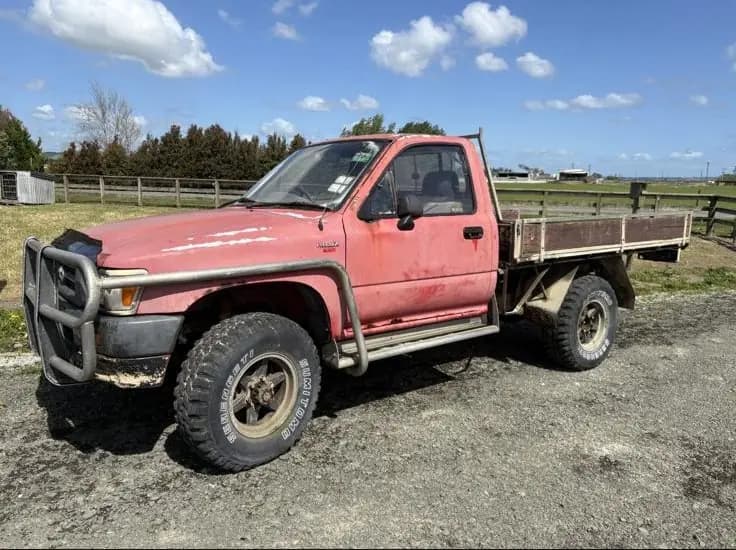 Damaged white ute with a dented bonnet, ready for cash for utes removal in Hamilton